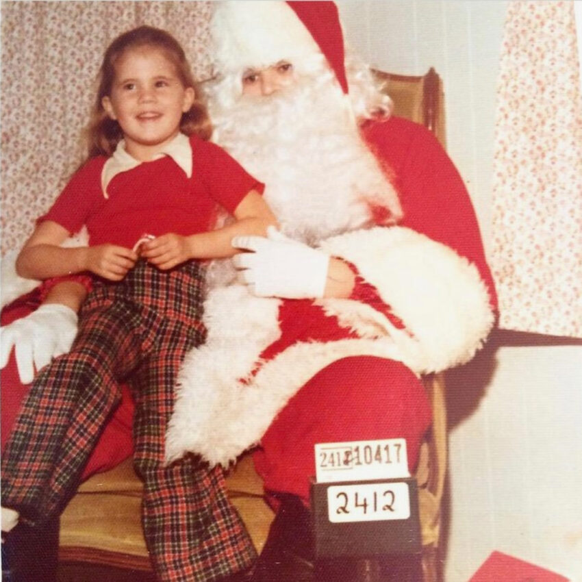 Deborah Russell and Santa posing for a holiday photo when she was young.